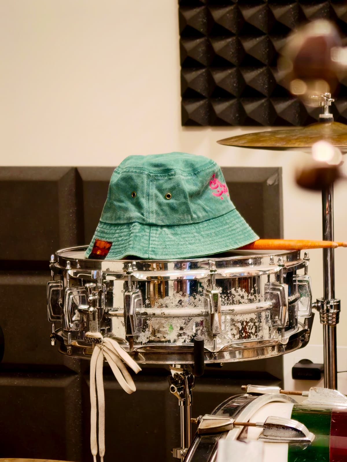 Green Bonne Chose bucket hat on a snare drum